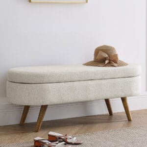 Beige upholstered storage bench placed along a wall in an entryway