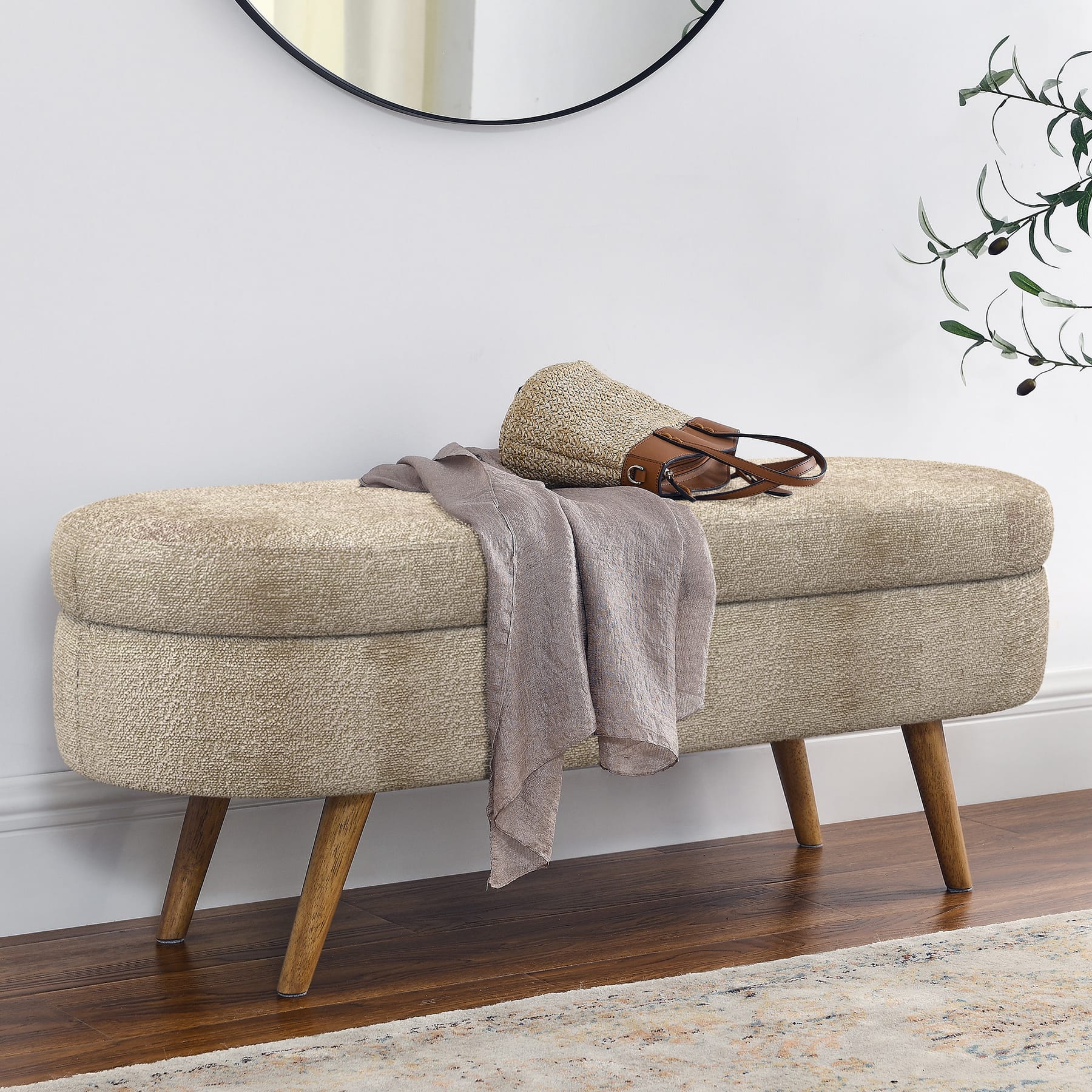 Brown upholstered storage bench placed along a wall in an entryway