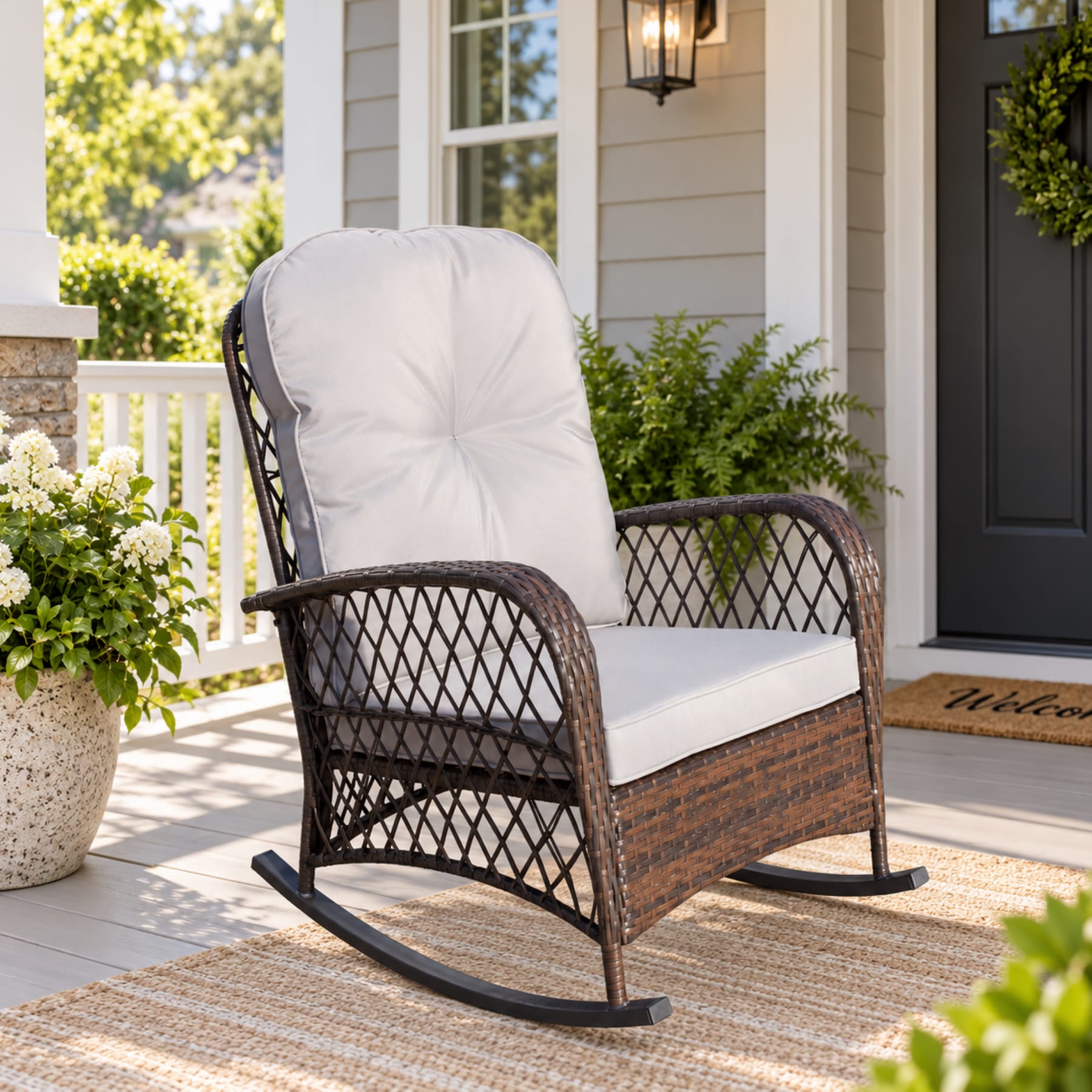 Brown PE rattan outdoor rocking chair with Gray seat and back cushions on a bright front porch